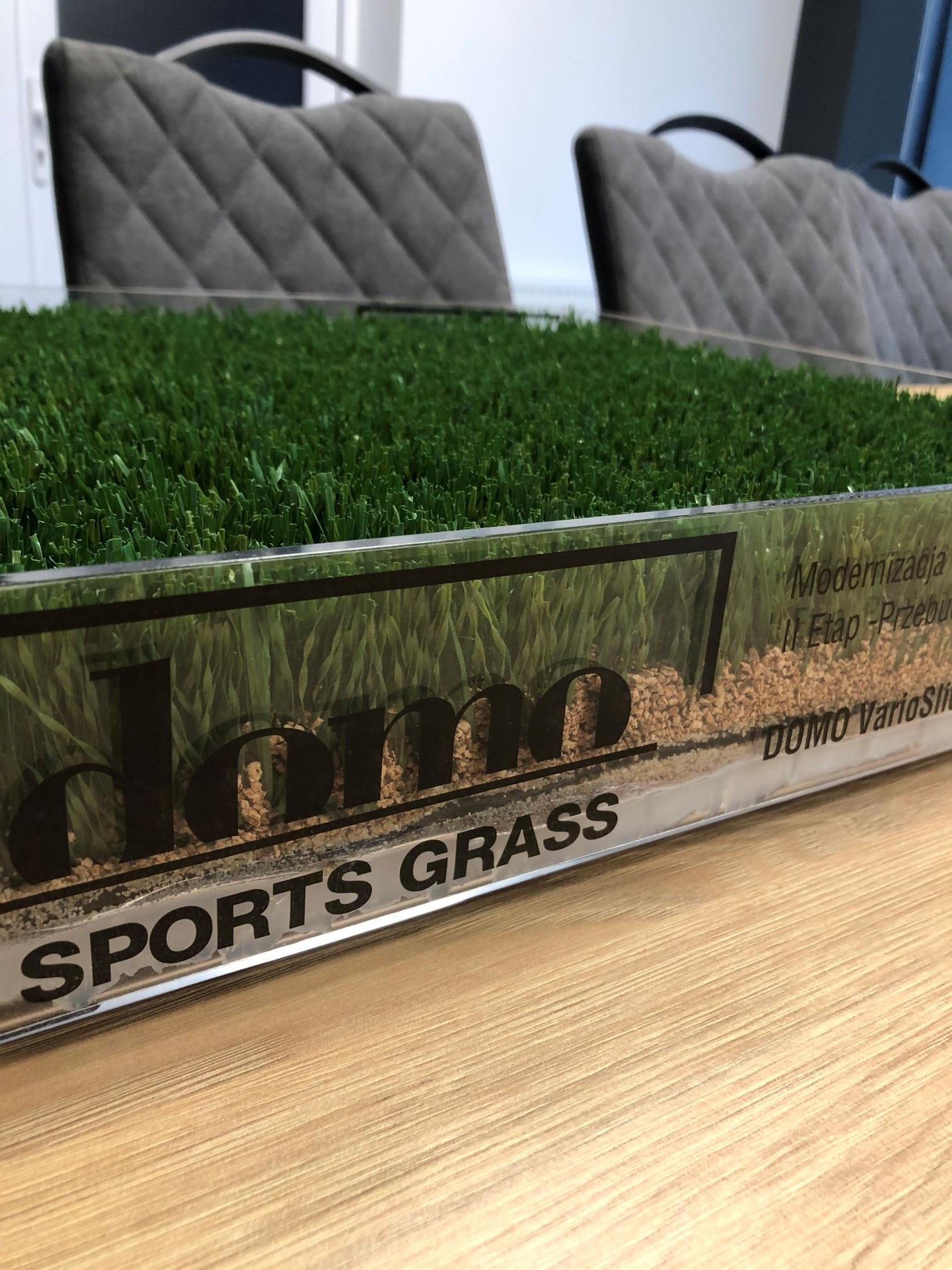 Zdjęcie przedstawia przekrój trawy, która została położona na boisku.