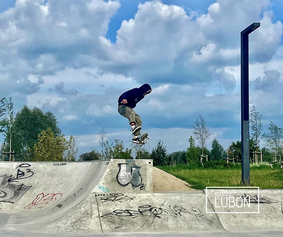 Na zdjęciu chłopak skacze na deskorolce w skateparku.